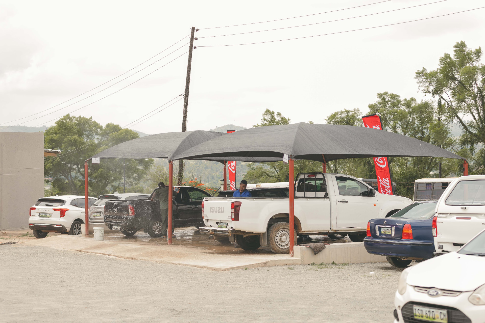 Cars parked under the shade canopies at MAPS Village Ngwane Park in Manzini